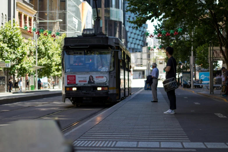 a person standing on the street in front of a bus