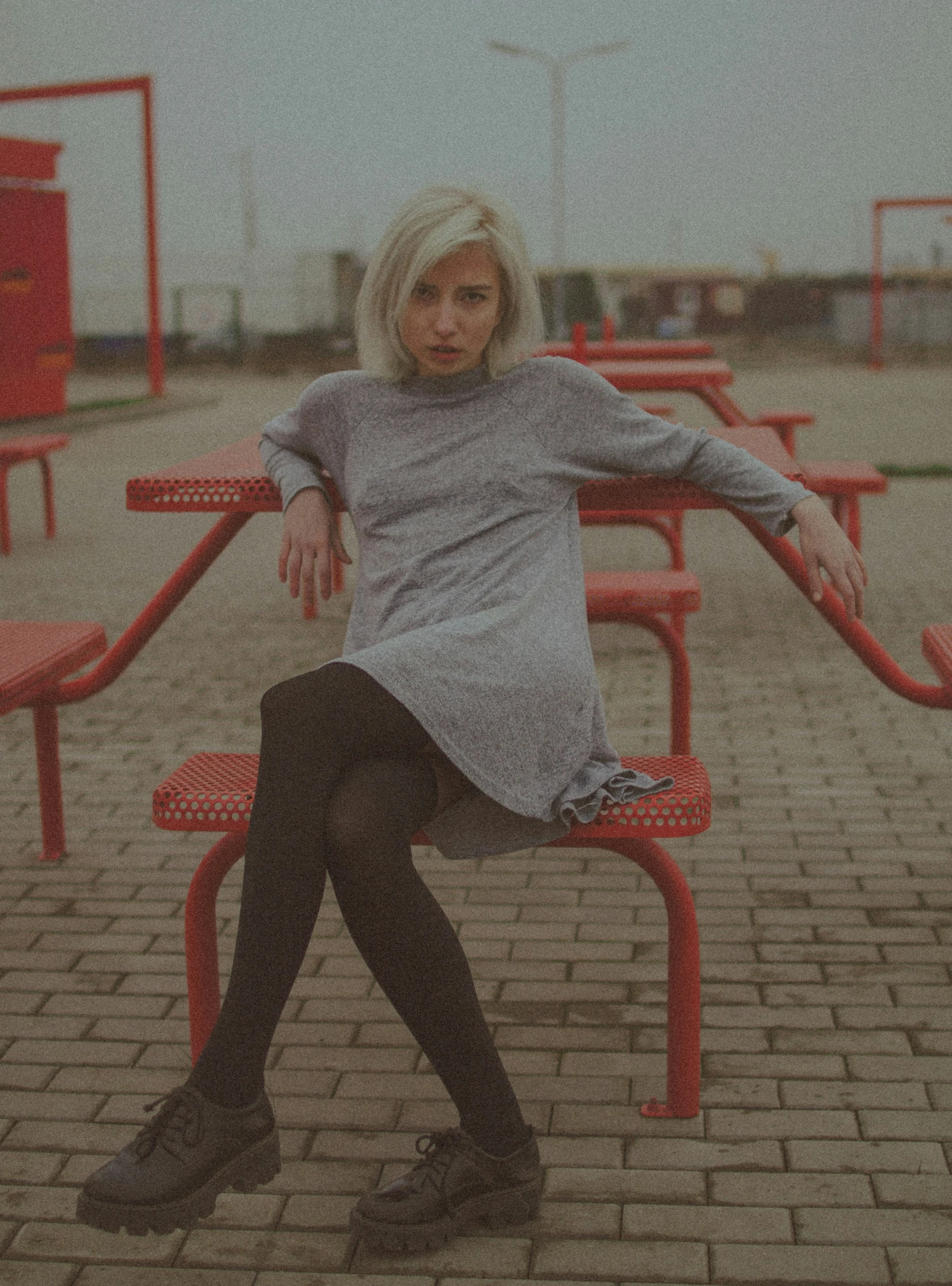 a woman sitting on a red bench near red seats