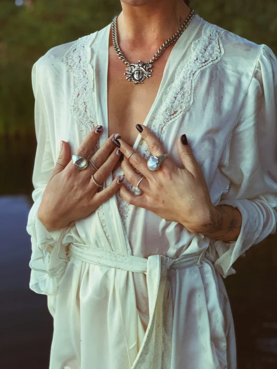 a woman with multiple hands holds a diamond necklace