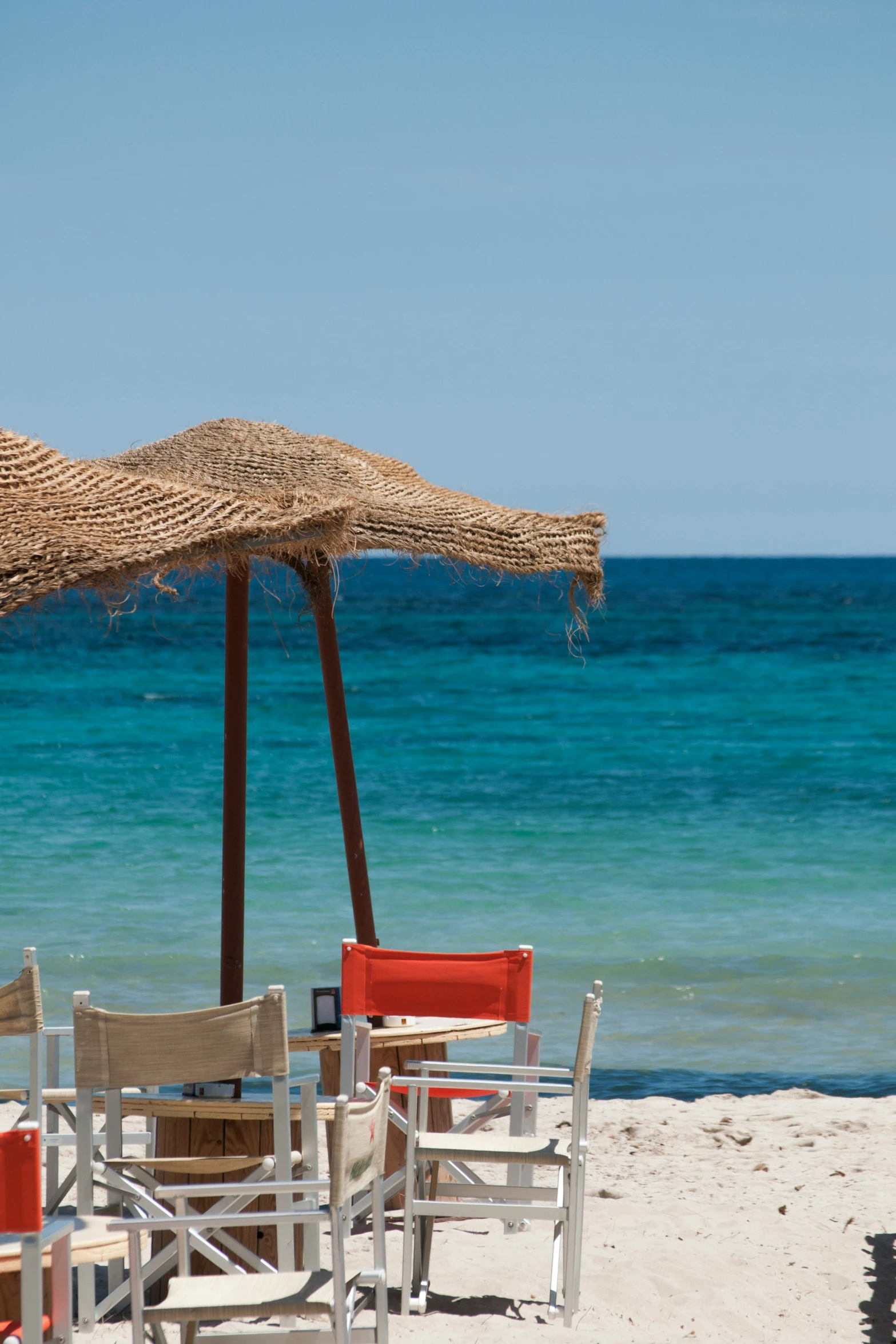 a beach set with some chairs and an umbrella