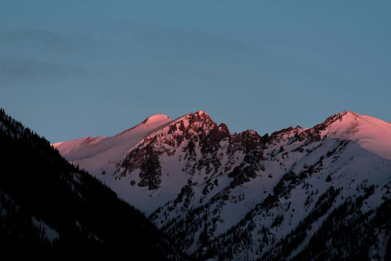 the mountains covered in snow during sunset