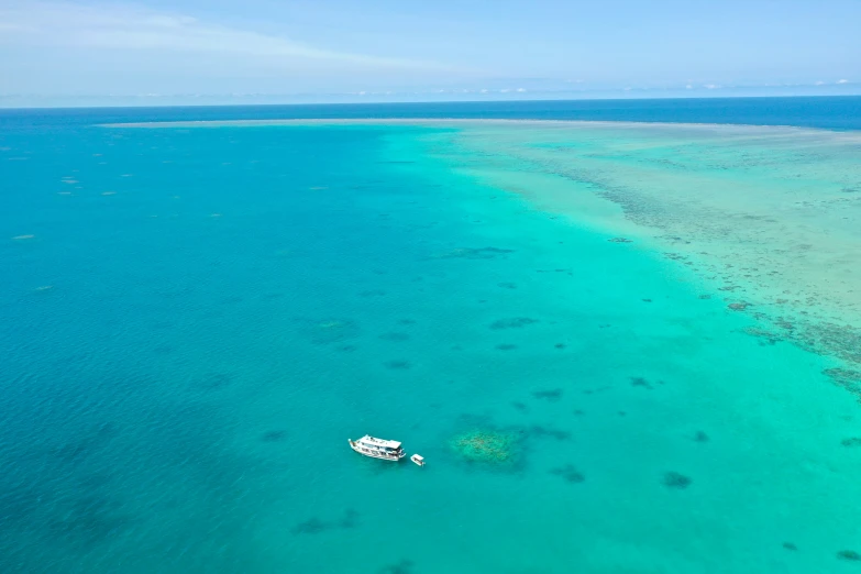 the white boat is near a very clear body of water