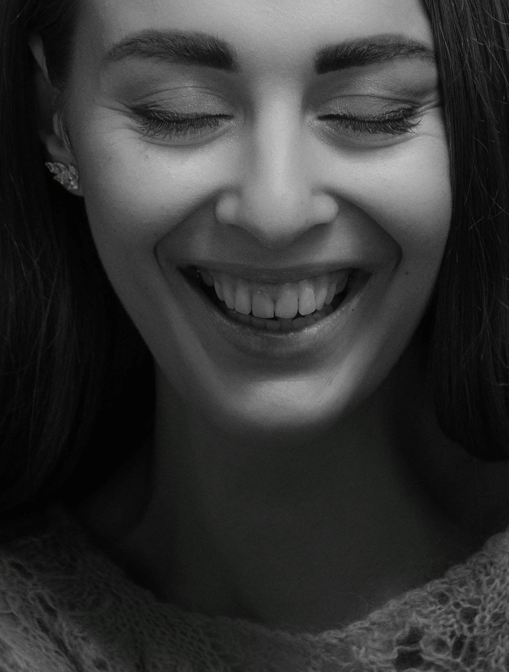 a woman with closed eyes and eyeshades smiles