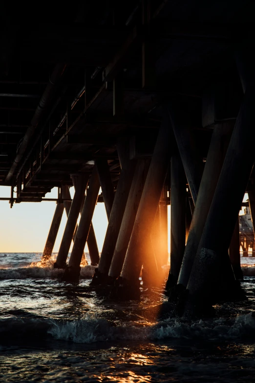 a couple of tall wooden pillars standing in the ocean