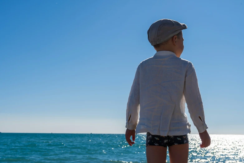 a little boy on top of a board looking at the water