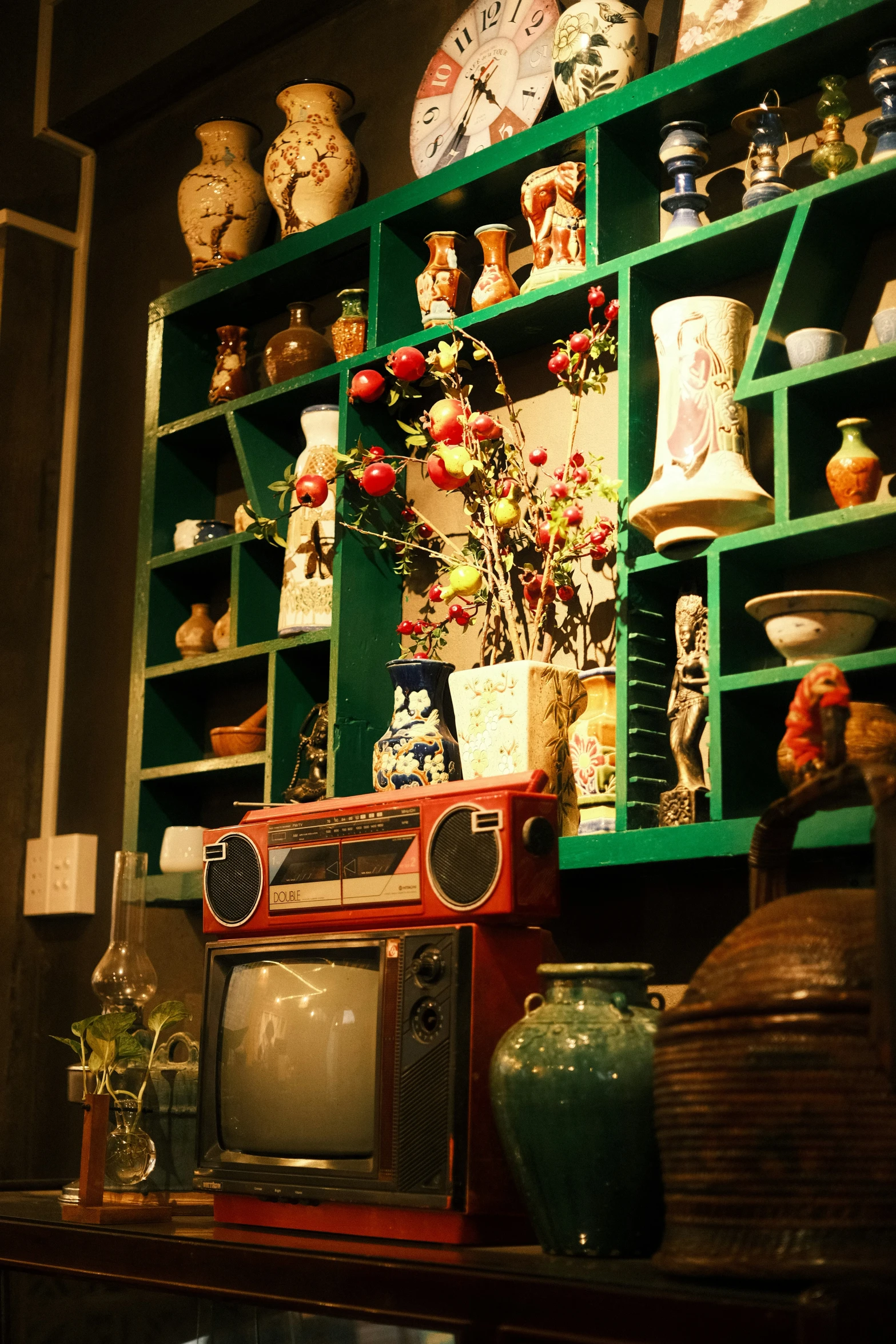 a television set in front of several shelves filled with old style decor