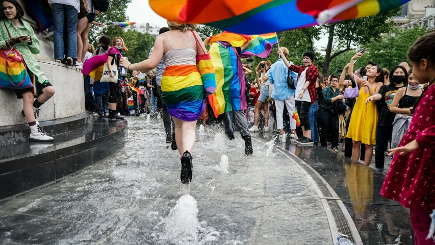 a woman in rainbow dress running through the street