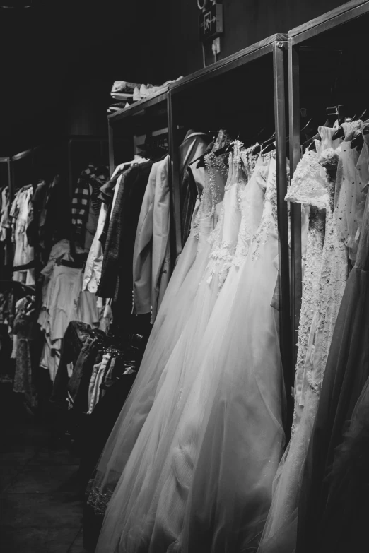 wedding gowns in a rack in a room