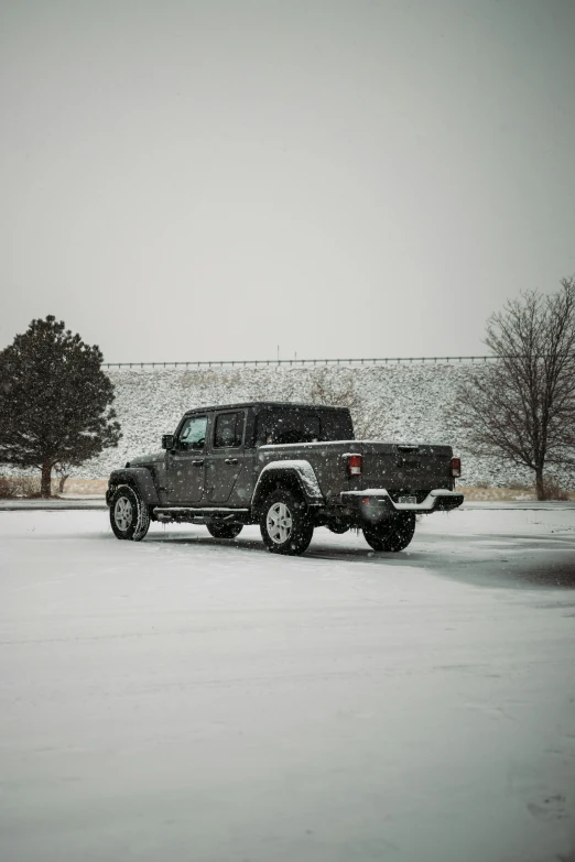 a black jeep parked on the street under snow