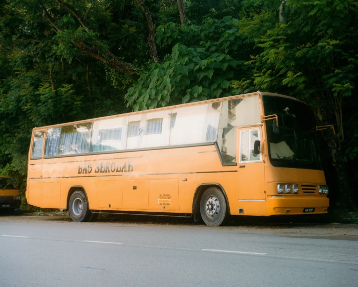 a very long yellow bus on a street