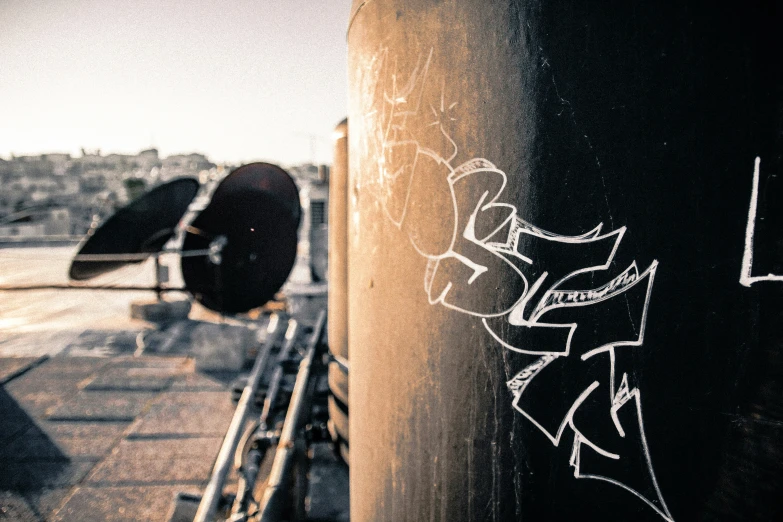 a black tank with graffiti is standing in front of another