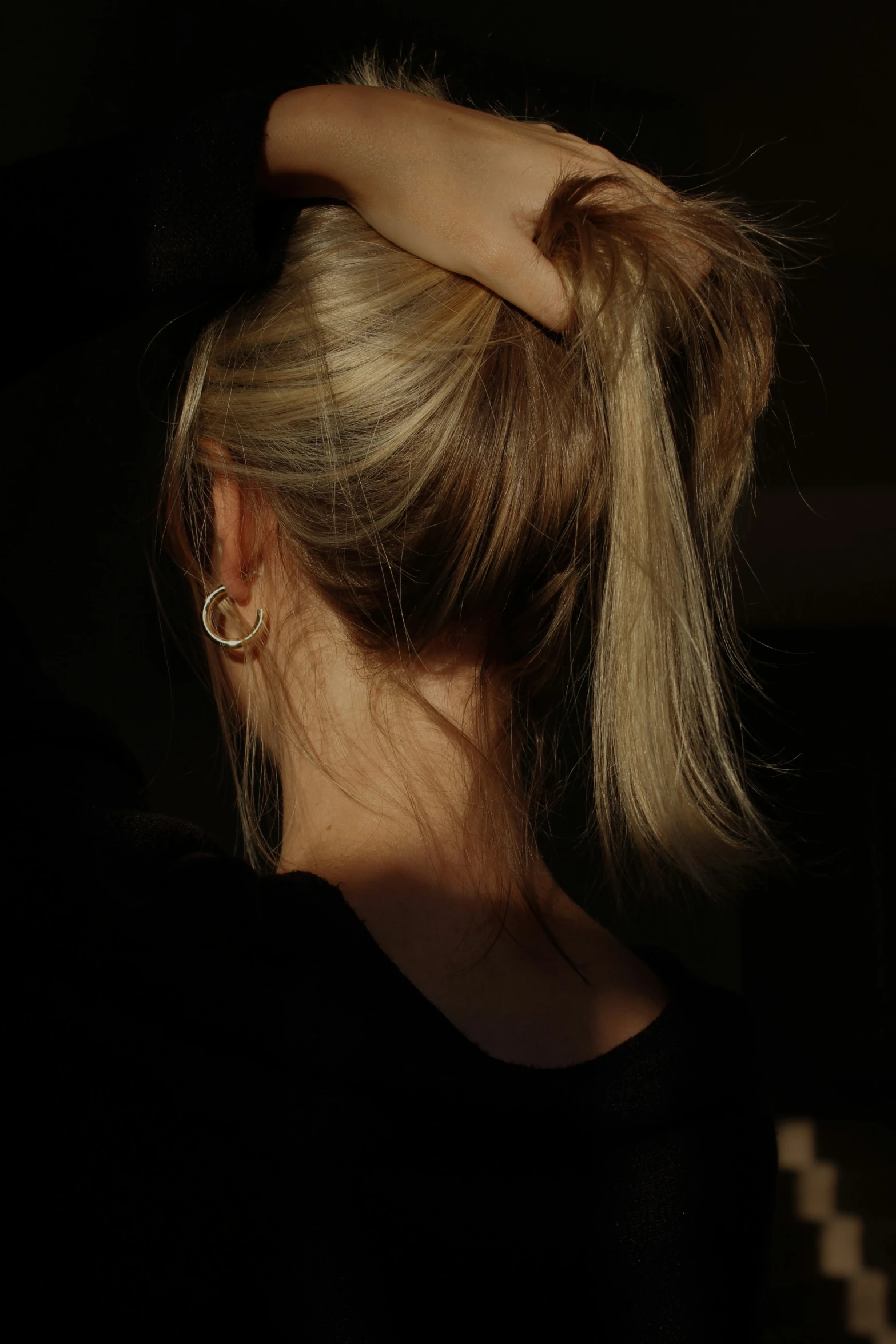 a woman with blonde hair wearing gold hoop earrings