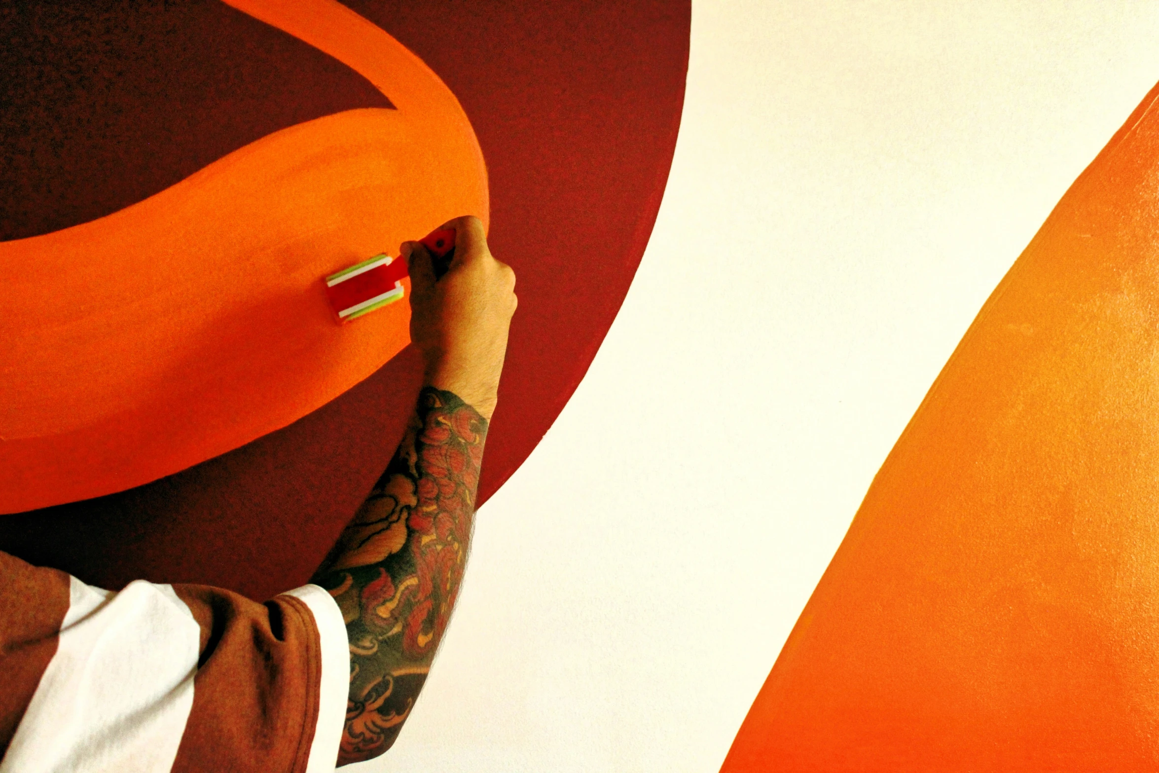 a man is painting on a wall with large circles