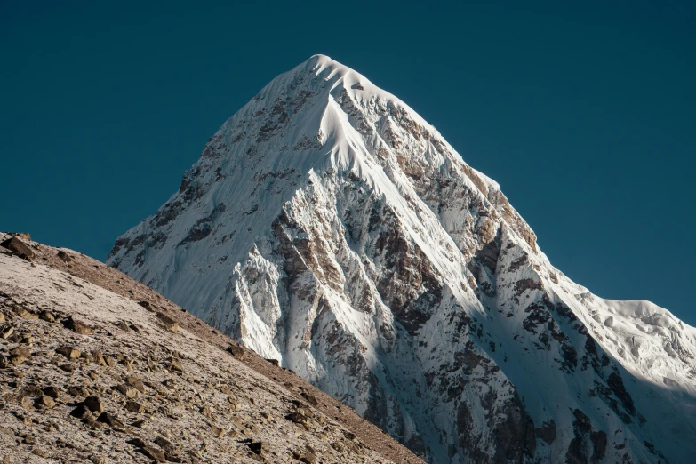 a very tall snow covered mountain on a clear day