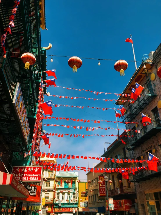 a group of red lanterns strung in the air above buildings