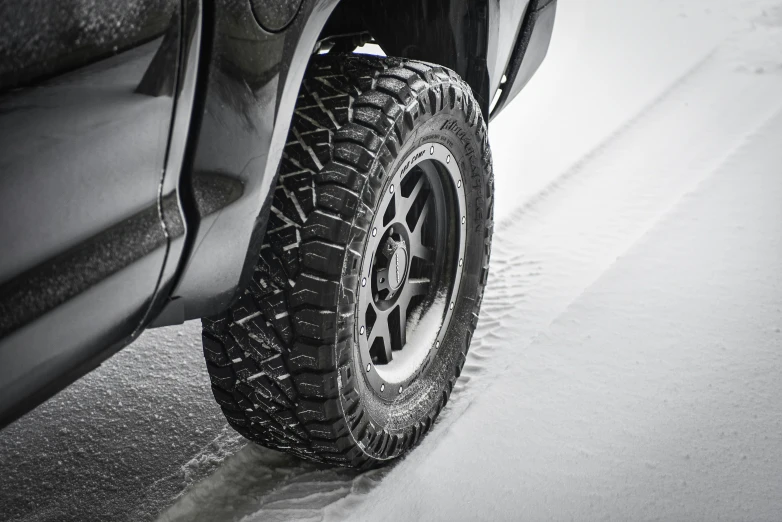 a big tire is shown on the front of a black truck