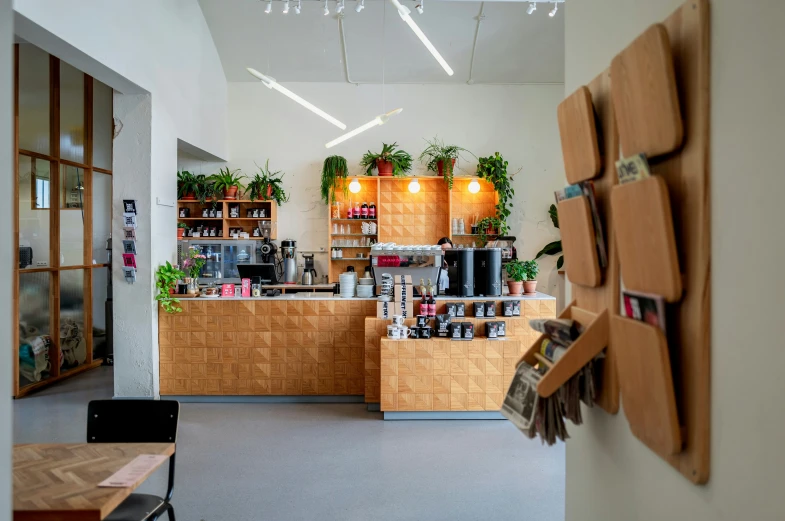 the inside of a small restaurant with wooden furniture and planters