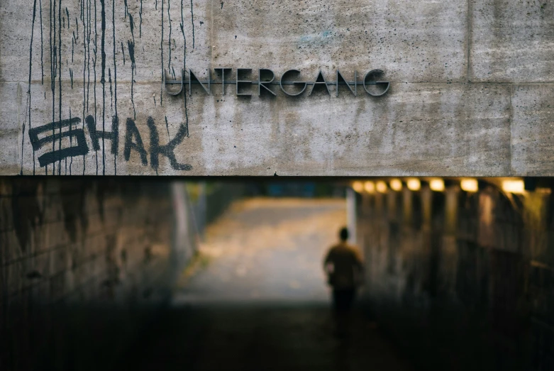 the person walking under the overpass is alone