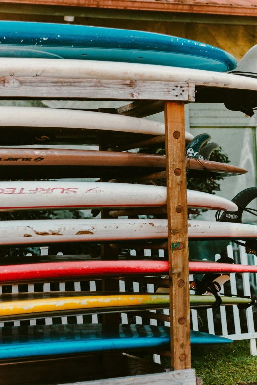 a bike leaning against some surfboards on a fence