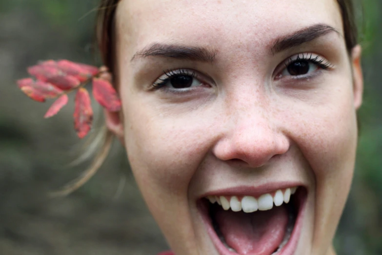 a woman smiling and holding a plant in her right hand