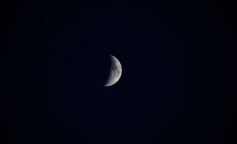 a half moon is seen in the sky with a blue background