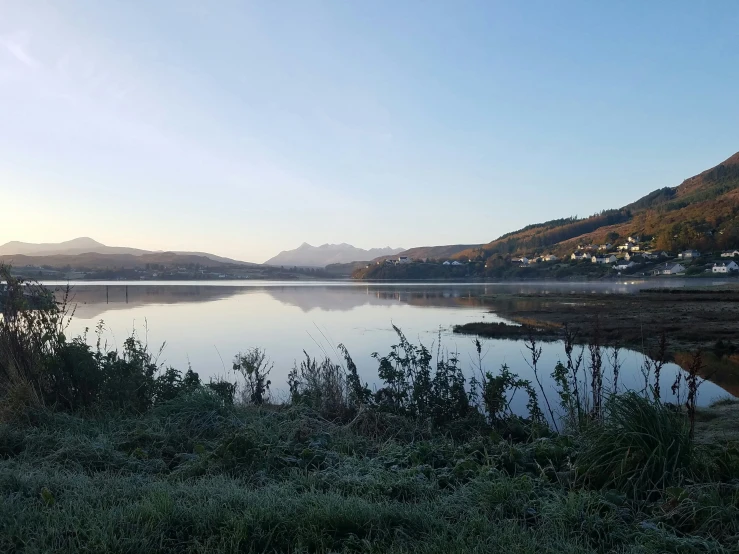 a body of water surrounded by hills and trees