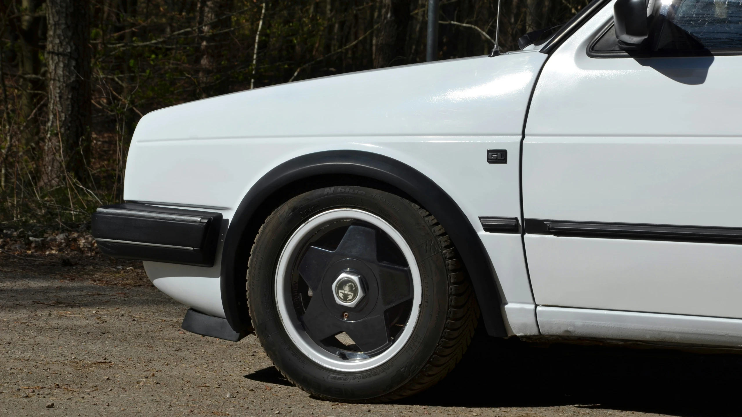 an older white car parked on the street