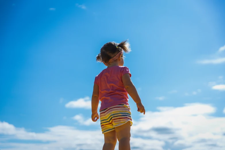 a child is flying a kite on a sunny day