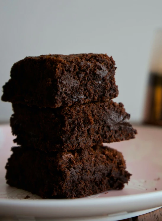 three square brownies stacked on each other on a plate