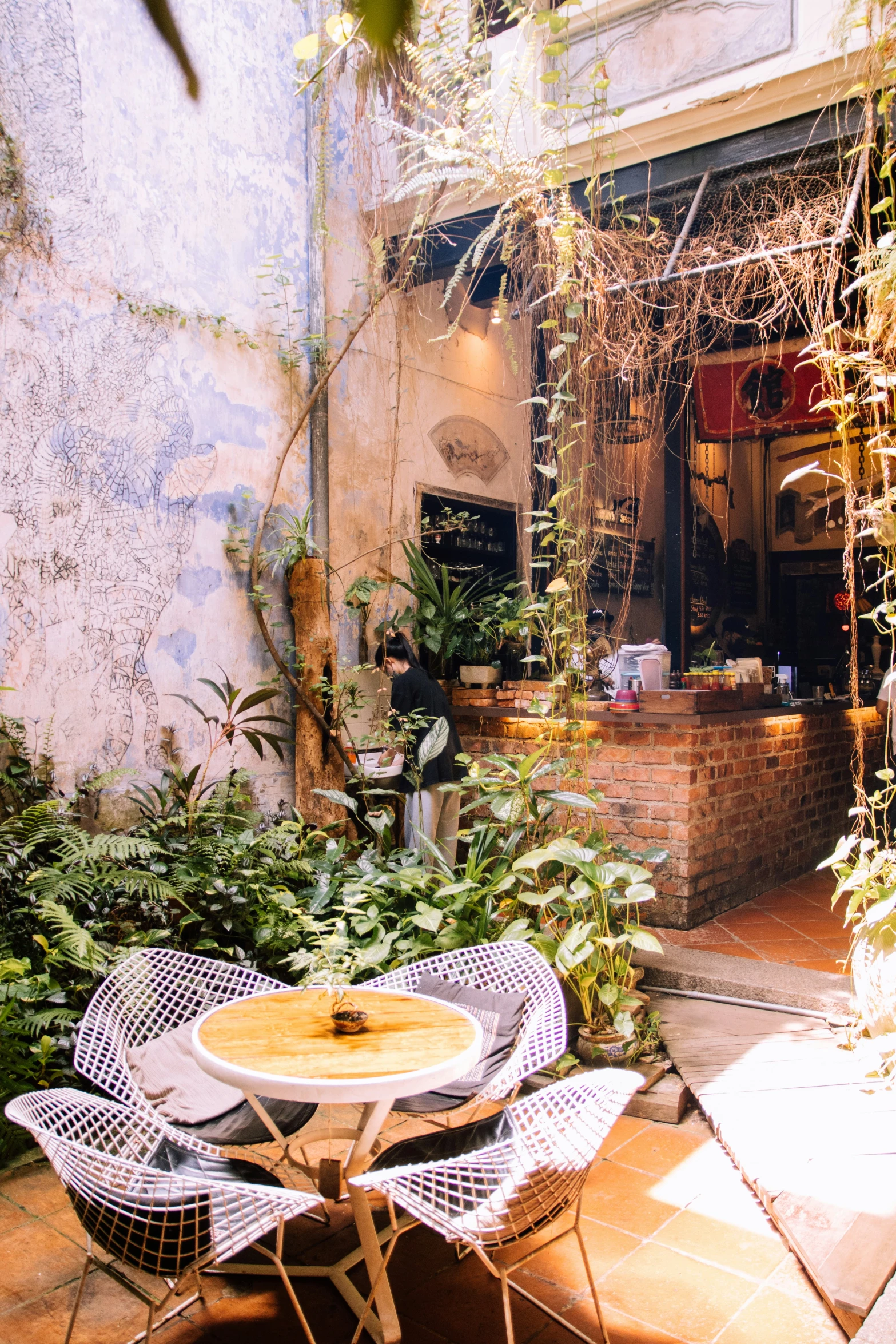 a table sits outside near many plants and flowers