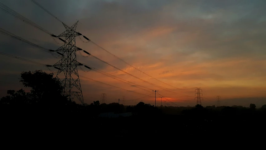 power lines with the sun setting in the background