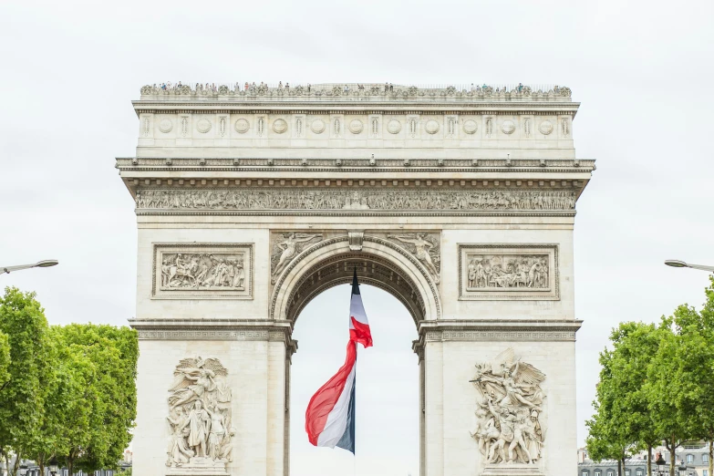 there is a tall white archway with a red, blue and white flag hanging in front of it