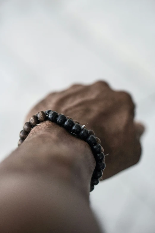 a wrist celet is shown with beads and black cord