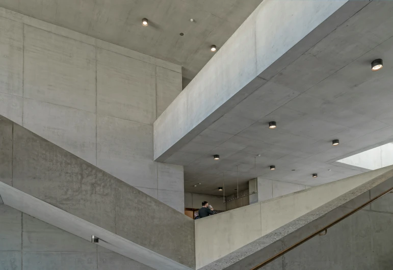 a man is seen on top of the stairwell as people look on