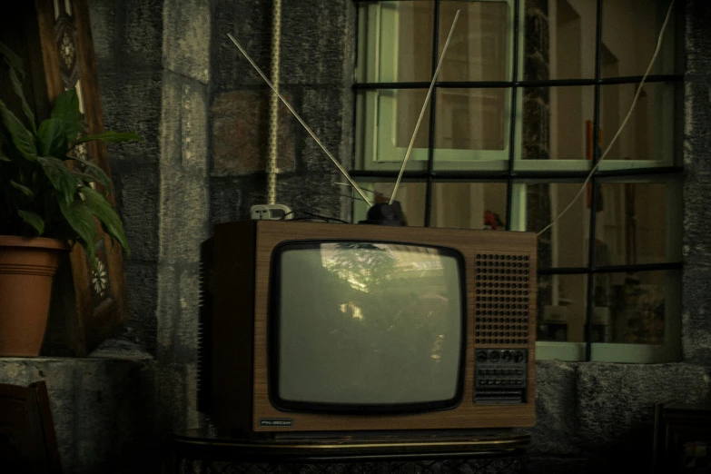a television sitting next to a window with curtains