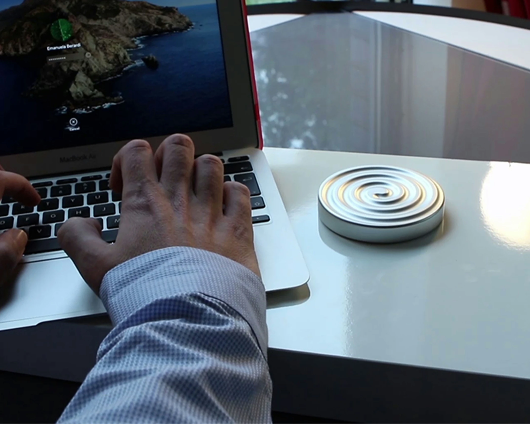 man using apple laptop computer at table with ipad in background