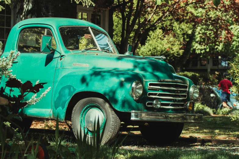 a man and child are in the back seat of a turquoise truck