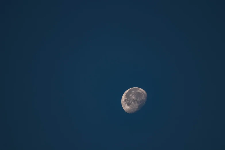 a full moon with a blue sky in the background