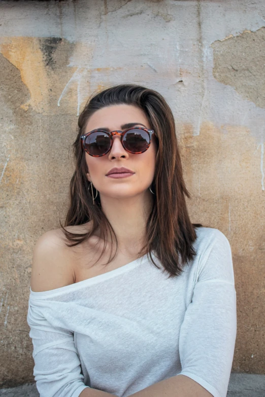 a woman in sunglasses is sitting on the ground