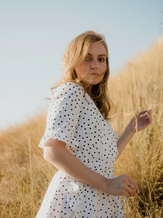 the girl is posing in the tall grass