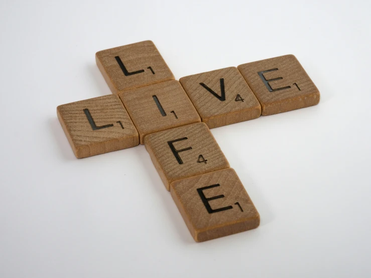 a cross made out of wood tiles that read live / die