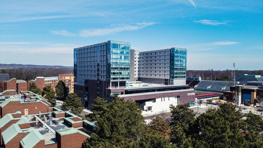 a large building with a glass front that is surrounded by trees