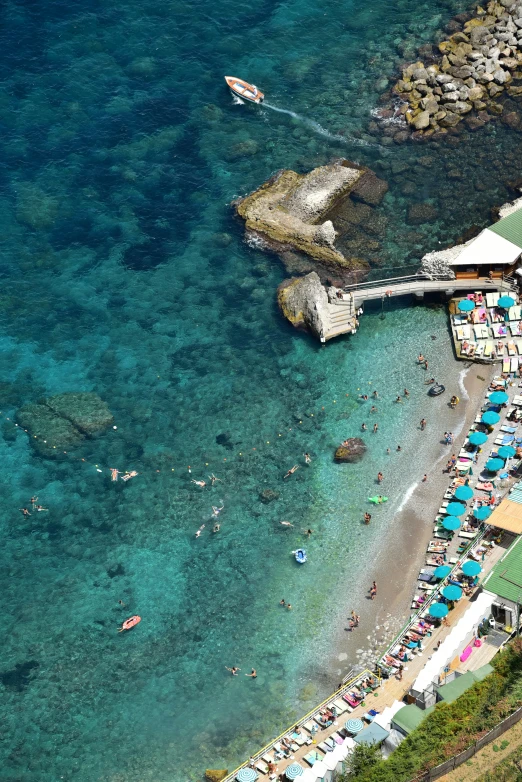 several lawn chairs and umbrellas along the shore near an ocean