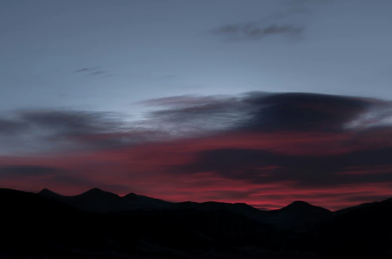 the sunset in the background, some mountains and a plane flying