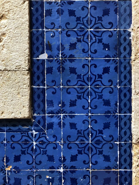 a blue tile with geometric designs on it in a wall
