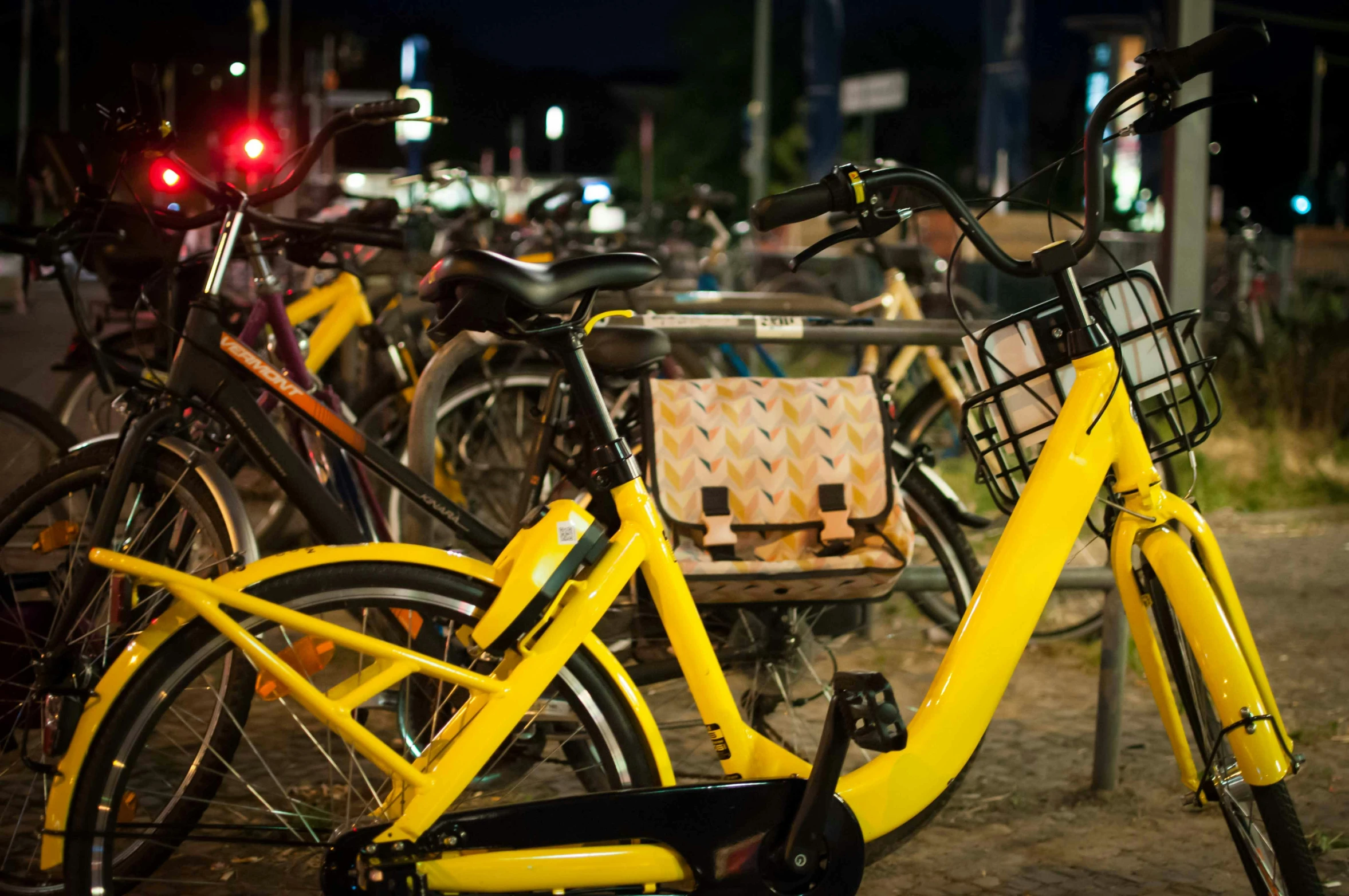 the bicycles are parked on the street beside the bench