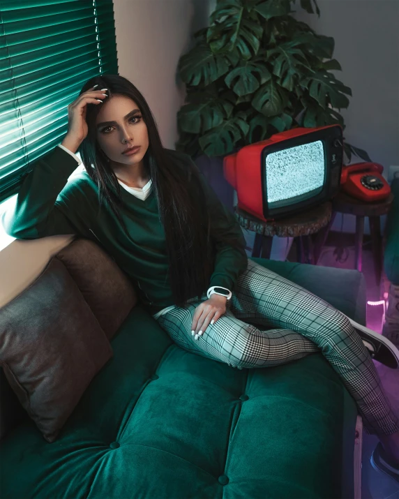 a woman wearing green posing on a couch