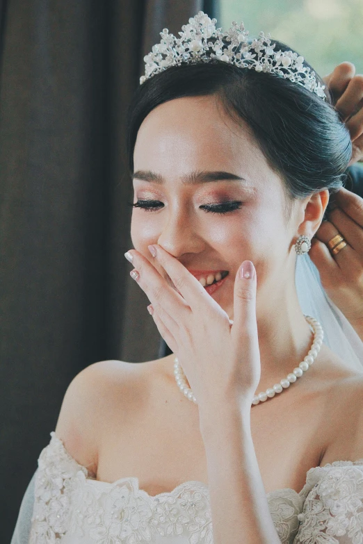 the bride smiles as she holds her face near her hands