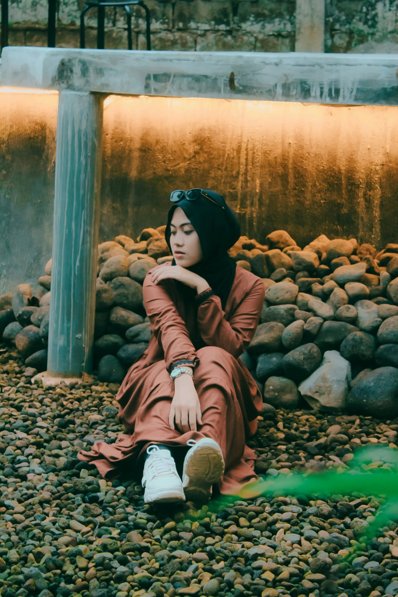 the woman is sitting down on the rocks