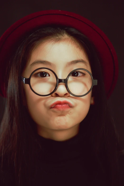 a woman wearing glasses and a red hat